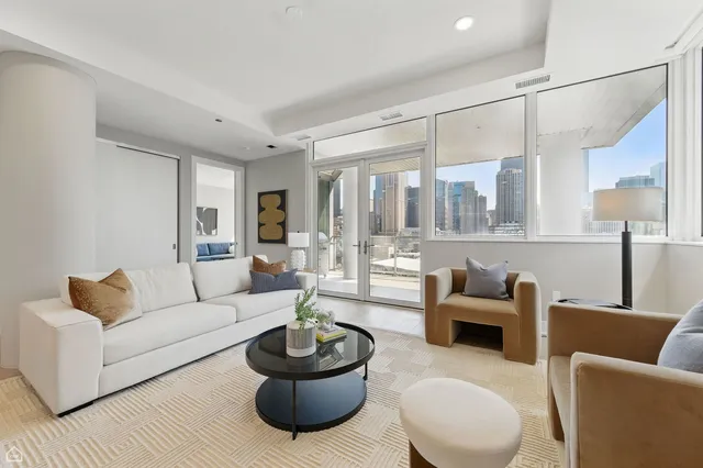 a living room with furniture and a view of kitchen