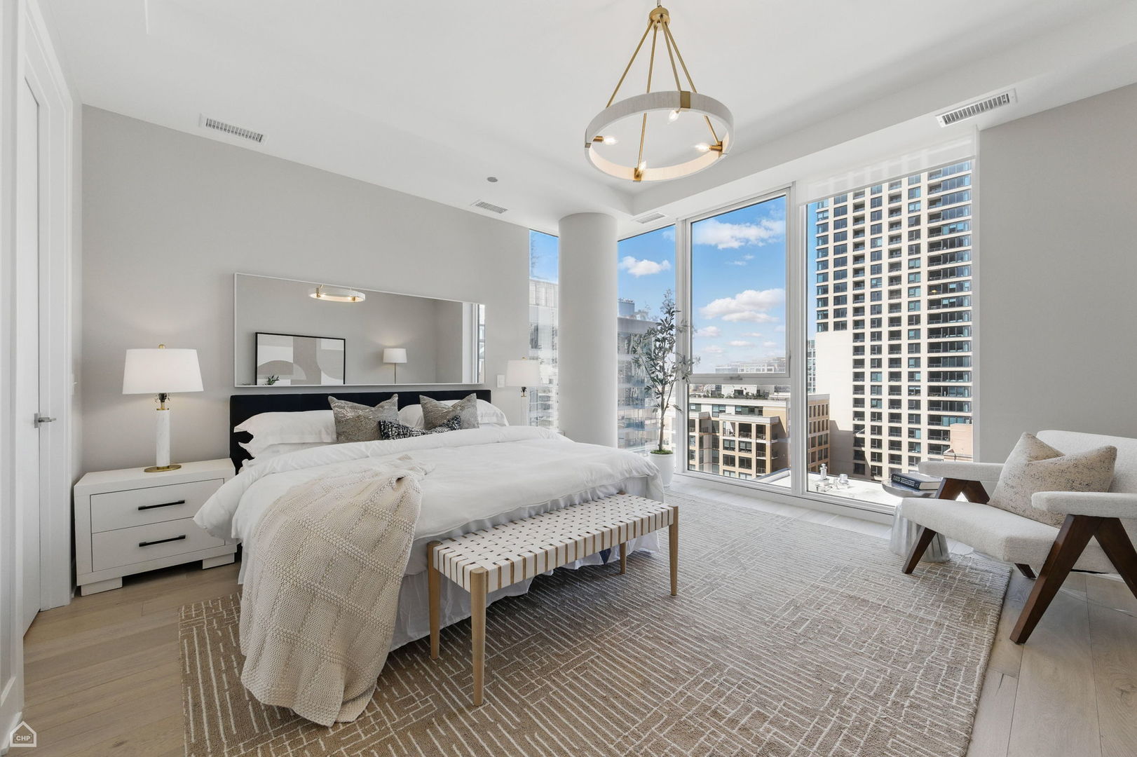 146 West Erie Street, Unit 702 Chicago, IL 60654 - Photo 9 of 17 a spacious bedroom with a bed and a chandelier