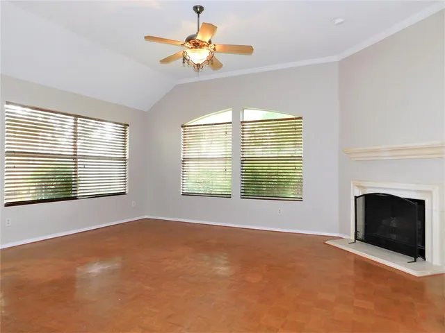 a view of an empty room with a window and a fireplace