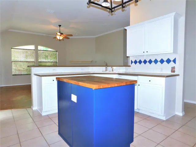 a view of kitchen with countertop cabinets and window