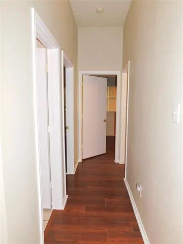 a view of a hallway with wooden floor