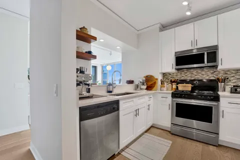 a kitchen with stainless steel appliances granite countertop a stove top oven a sink and dishwasher