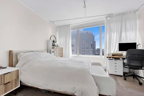 a bedroom with a bed and a desk