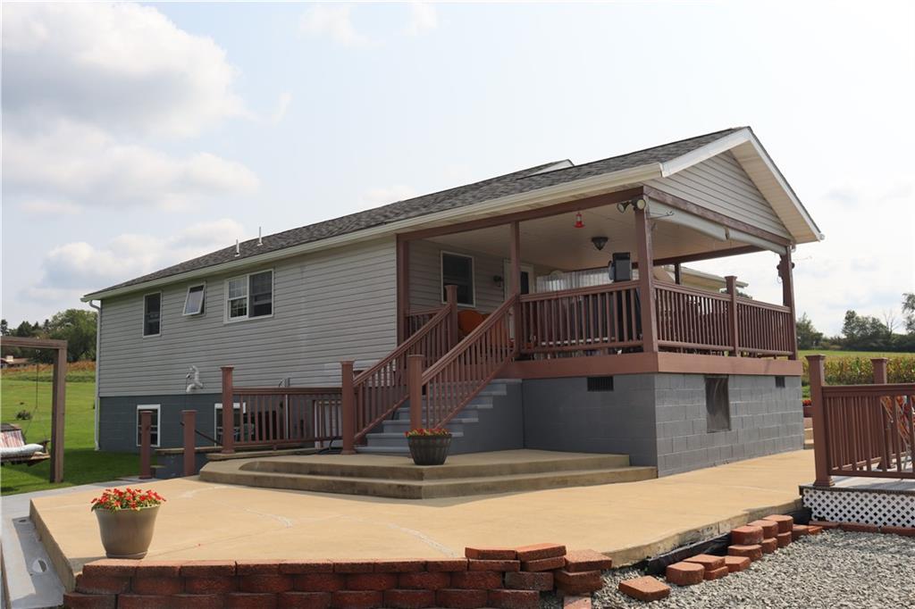 Front roofed deck, side concrete patio.