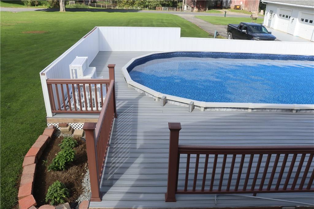 View of swimming pool from front roofed deck.