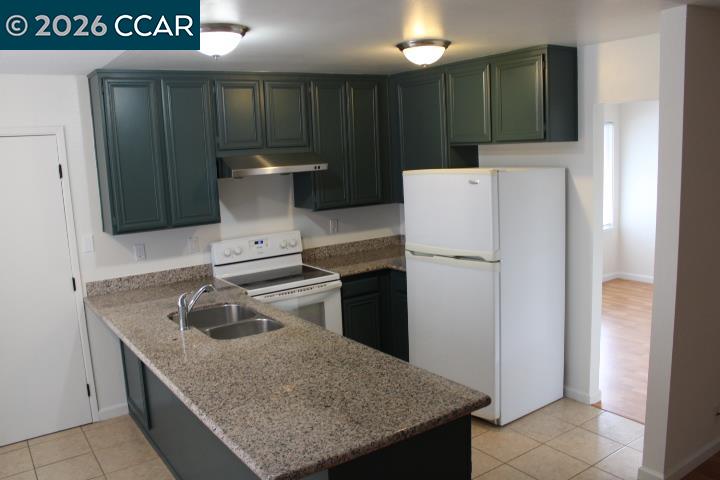 2152 Blue Jay Circle Pinole, CA 94564 - Photo 8 of 31 a kitchen with a sink a refrigerator and a stove
