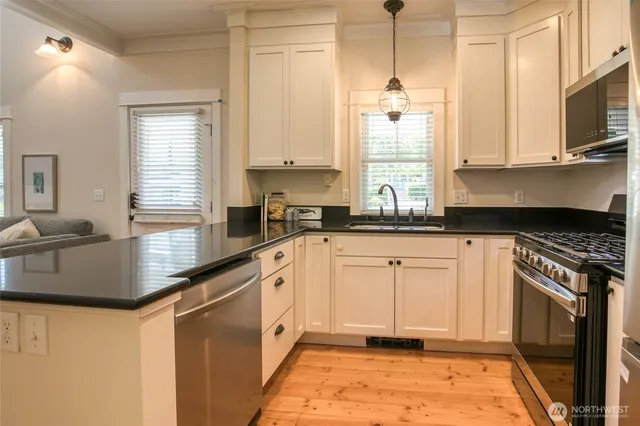 a kitchen with stainless steel appliances granite countertop a sink a stove and cabinets
