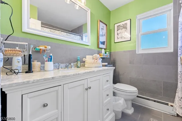 a bathroom with a granite countertop sink mirror vanity and toilet