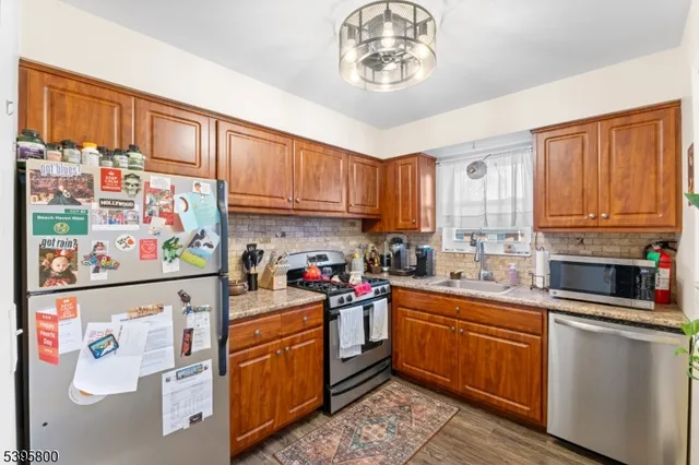 a kitchen with stainless steel appliances a stove a sink and cabinets