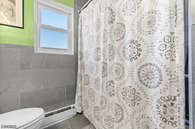 a bathroom with a toilet and a shower curtain