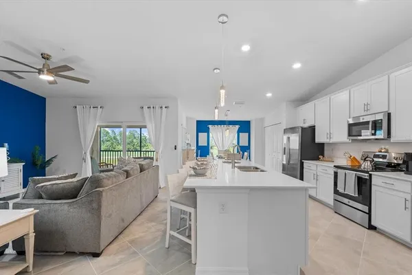 a kitchen with stainless steel appliances granite countertop white cabinets a stove top oven and dishwasher