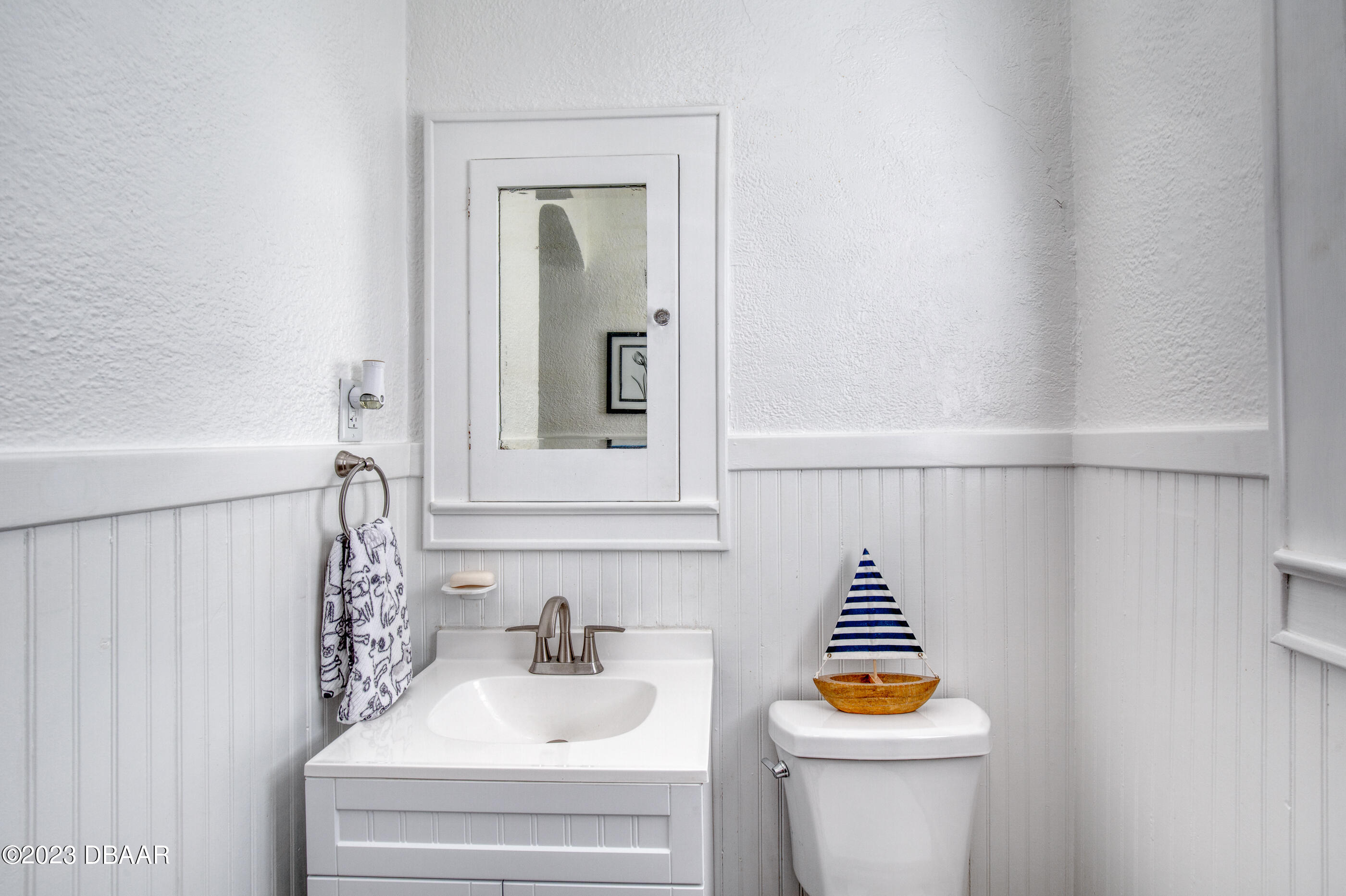 42 River Beach Drive Ormond Beach, FL 32176 - Photo 42 of 74 a bathroom with a sink and mirror with toilet