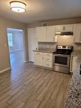 a kitchen with granite countertop a stove and a sink