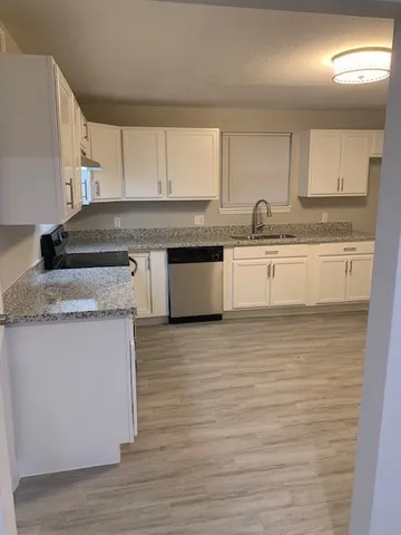 a kitchen with stainless steel appliances granite countertop a sink stove and cabinets