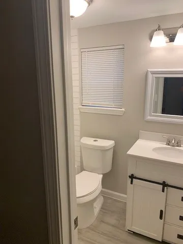 a bathroom with a toilet a sink a vanity and mirror