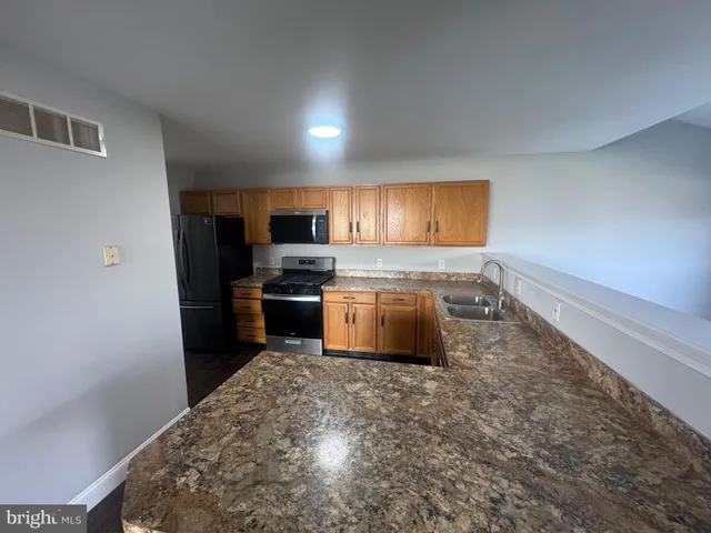 a kitchen with stainless steel appliances a refrigerator a stove a sink and a microwave