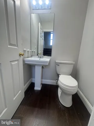 a bathroom with a toilet a sink and mirror