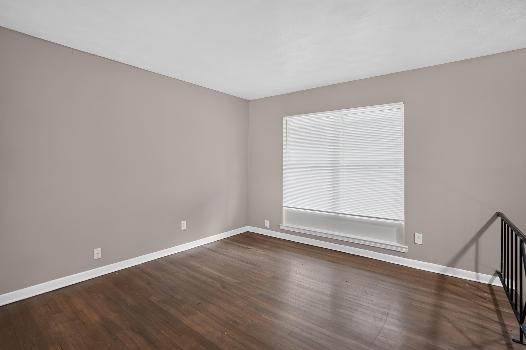 3391 South Perkins Road Memphis, TN 38118 - Photo 12 of 16 Expansive room featuring wood-finish flooring, neutral-toned walls, a large window with horizontal blinds, and white baseboards