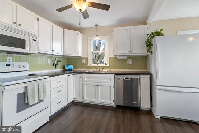 a kitchen with stainless steel appliances granite countertop a sink a stove a refrigerator and cabinets