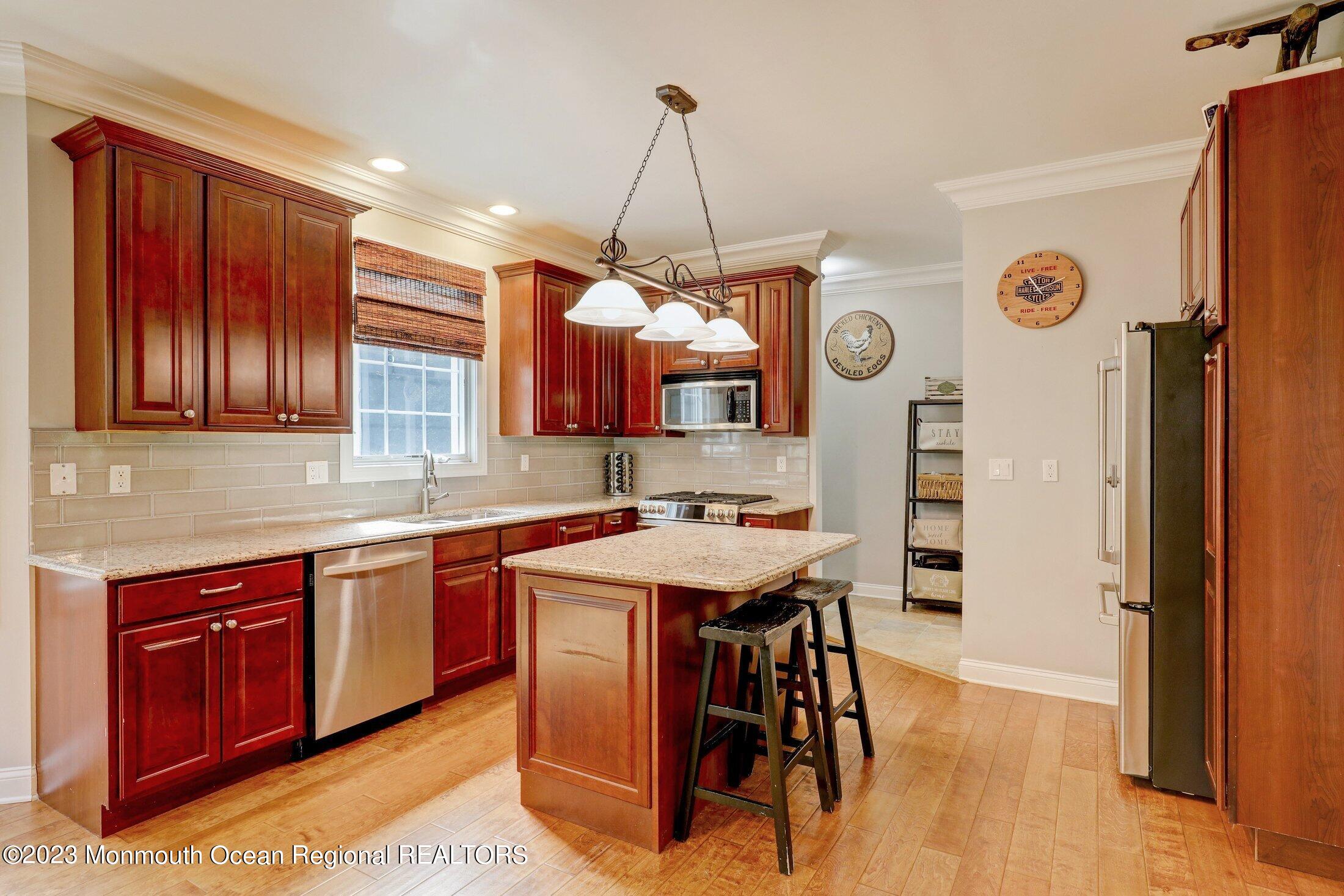 352 Lanes Pond Road Howell, NJ 07731 - Photo 15 of 67 a kitchen with stainless steel appliances granite countertop a stove a refrigerator a sink dishwasher and white cabinets with wooden floor