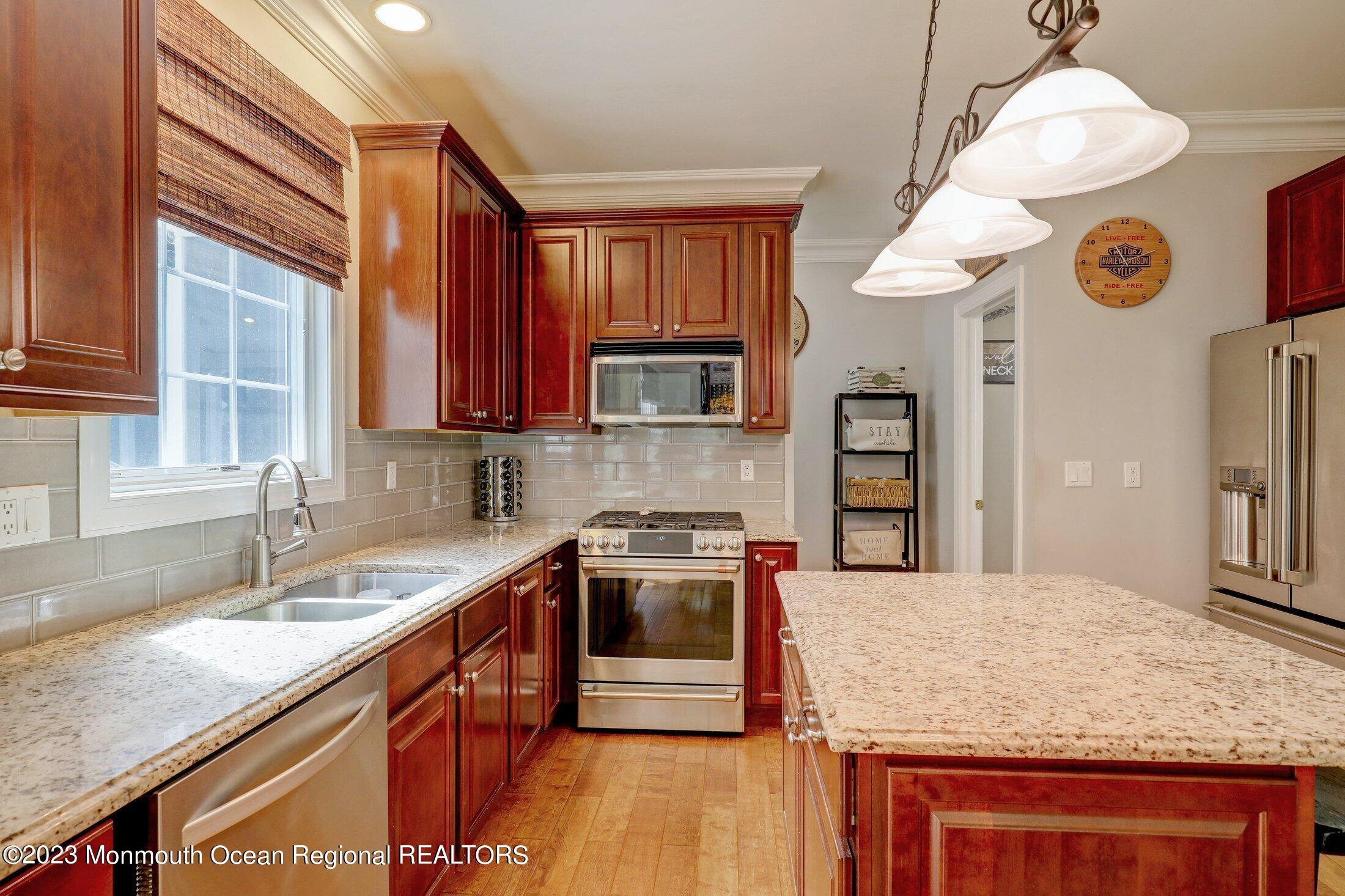 352 Lanes Pond Road Howell, NJ 07731 - Photo 17 of 67 a kitchen with stainless steel appliances granite countertop a sink a stove and a microwave