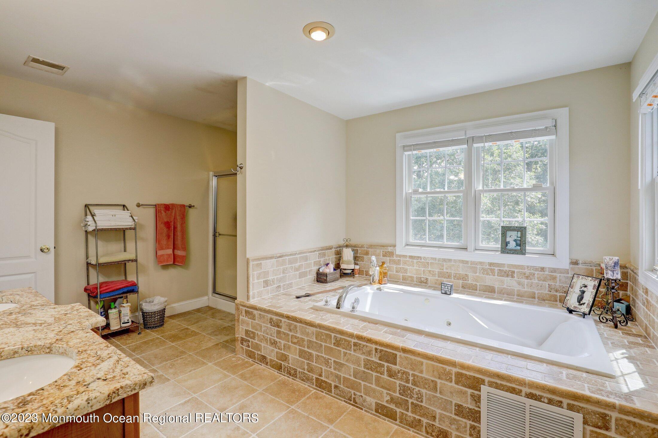 352 Lanes Pond Road Howell, NJ 07731 - Photo 32 of 67 a bathroom with a tub sink and a window