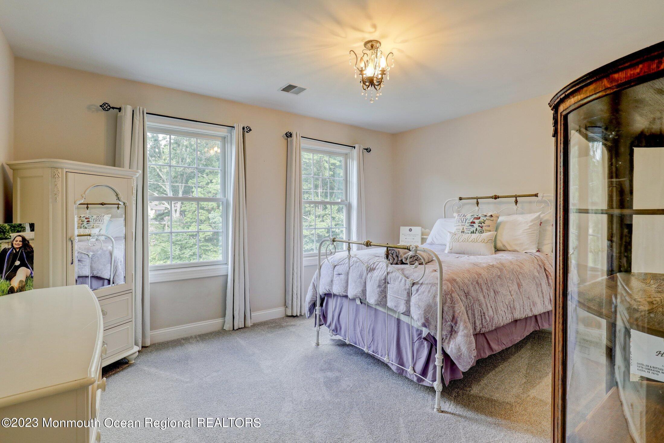 352 Lanes Pond Road Howell, NJ 07731 - Photo 35 of 67 a bed room with a bed and a chandelier