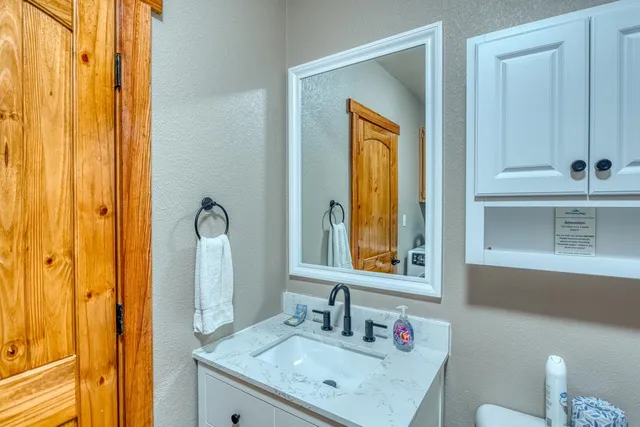 a bathroom with a sink vanity granite and a mirror