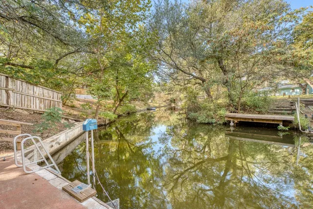 a view of residential houses with yard and wooden fence