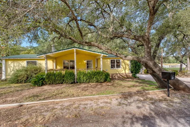a front view of a house with a yard and potted plants