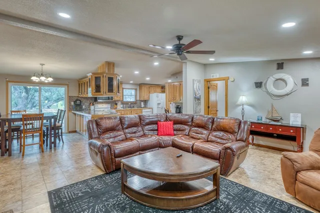 a living room with furniture a rug and kitchen view