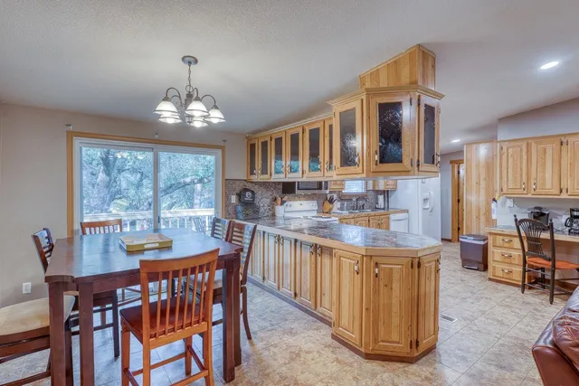 a view of a dining room with furniture a chandelier and wooden floor