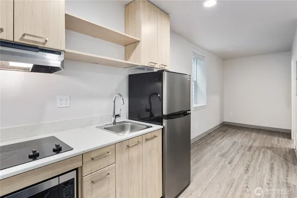 a view of an empty room with closet and wooden floor