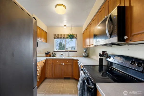 a kitchen with a sink appliances and cabinets