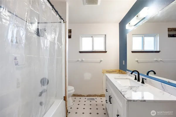 a bathroom with a sink a toilet a shower and a mirror