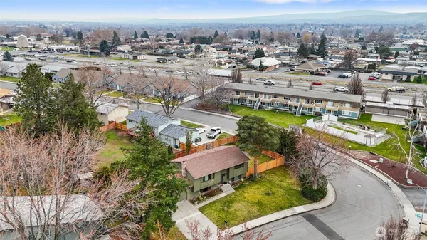 an aerial view of a house with a yard and large tree