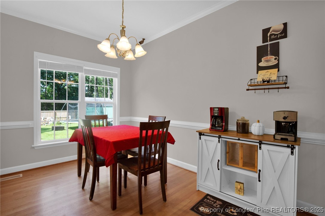 1199 Hunters Trail Hope Mills, NC 28348 - Photo 13 of 45 a view of a dining room with furniture a rug and wooden floor