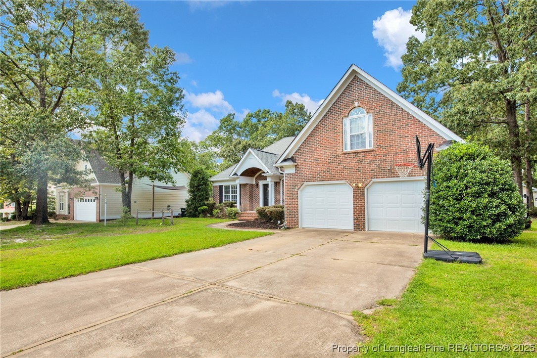 1199 Hunters Trail Hope Mills, NC 28348 - Photo 2 of 45 a front view of a house with a yard and garage