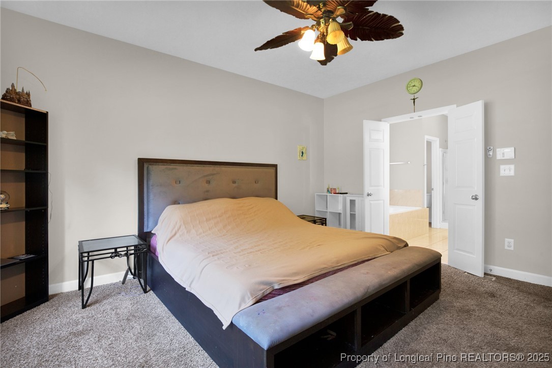 1199 Hunters Trail Hope Mills, NC 28348 - Photo 21 of 45 a bedroom with a bed and a chandelier