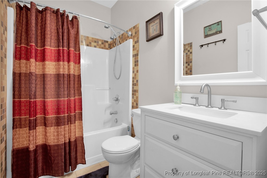 1199 Hunters Trail Hope Mills, NC 28348 - Photo 31 of 45 a bathroom with a sink toilet a shower curtain and a mirror