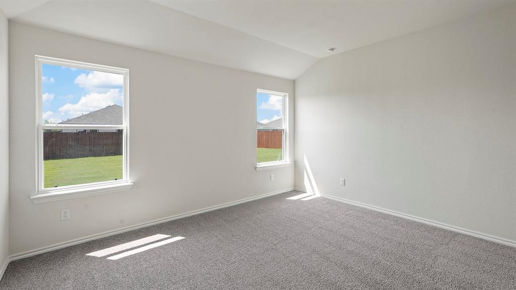 1675 Mantle Road Crandall, TX 75114 - Photo 16 of 27 Carpeted room featuring two windows with white trim and a vaulted ceiling