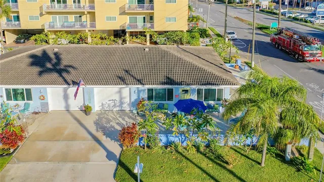 a front view of a house with a yard and potted plants