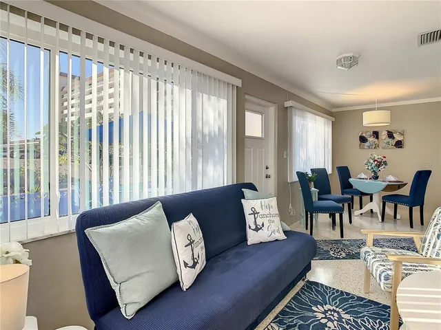 a living room with furniture a flat screen tv and a window