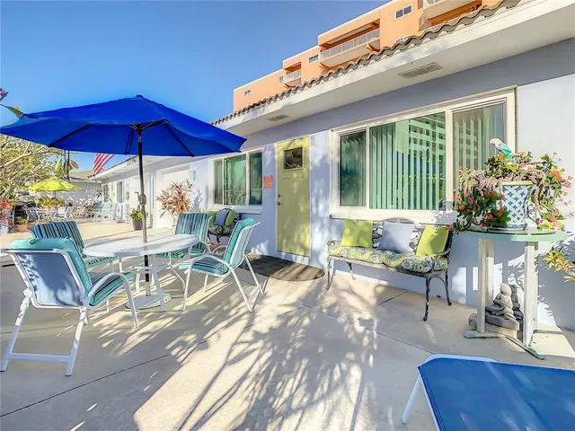 a view of a patio with a table and chairs under an umbrella