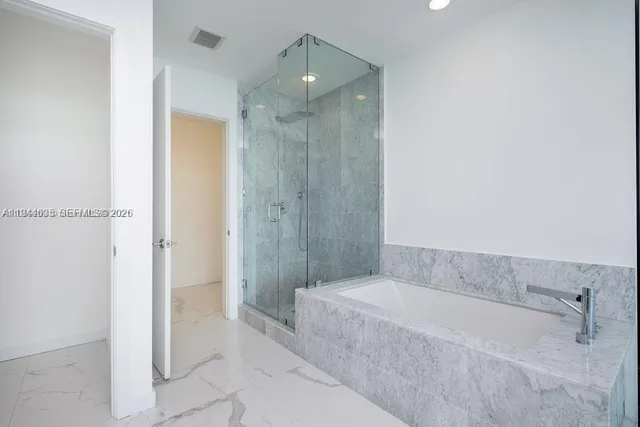 a spacious bathroom with a bathtub and shower