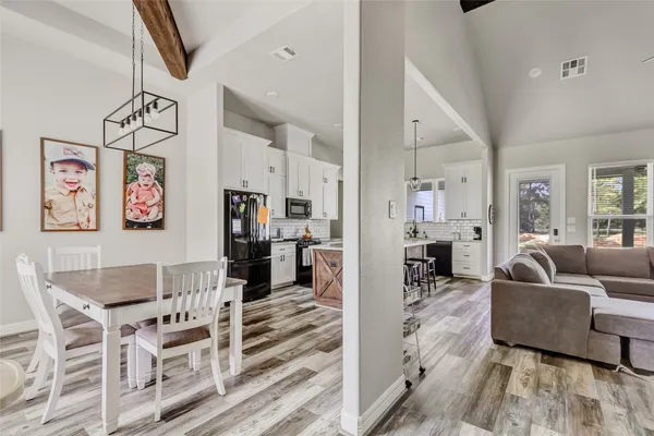 a view of a livingroom with wooden floor and a bathroom space