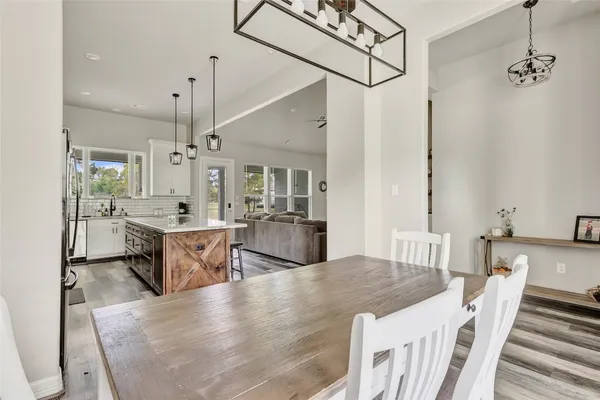 a large kitchen with granite countertop lots of counter top space a sink stainless steel appliances and cabinets