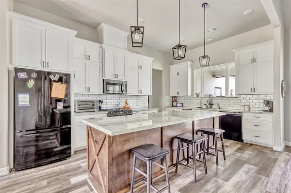 a kitchen with stainless steel appliances granite countertop a sink and cabinets