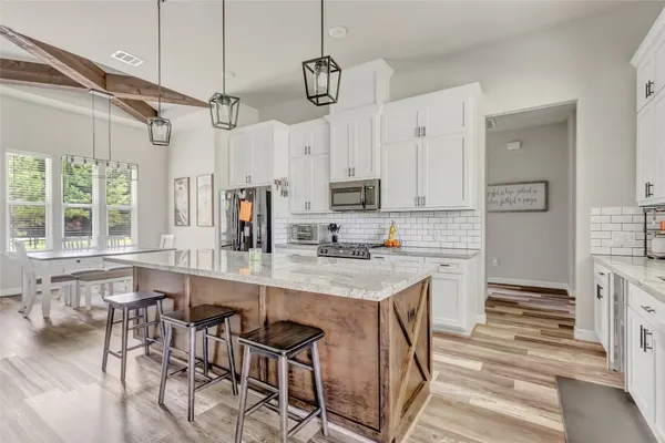 a kitchen with kitchen island granite countertop a sink counter top space appliances and cabinets