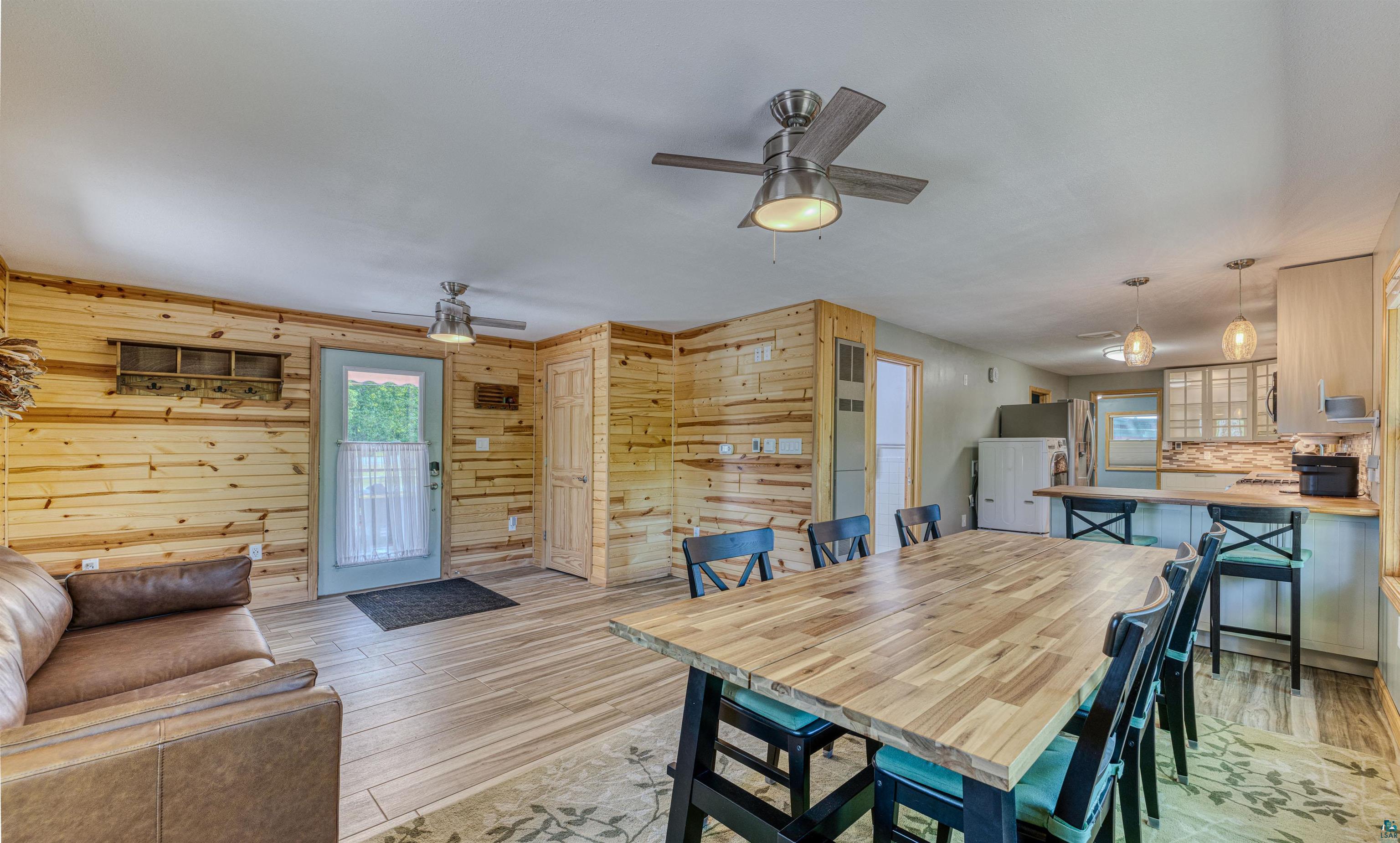 66075 Rooster Road Iron River, WI 54847 - Photo 20 of 52 Open-concept room featuring wood-finish flooring, natural wood plank wall finishes, and a contemporary ceiling fan